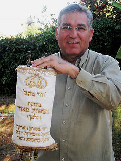 "הספר מצא אותי". יעקב מאור אוחז בספר התורה של סבו (צילום: יאיר מאור)