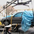 מכוניתו של המדען רושן מפונה היום מהרחוב בבירת איראן 