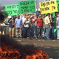 עובדי נמל אשדוד מפגינים ומבעירים צמיגים נגד החלטת הממשלה להפריט את הנמלים