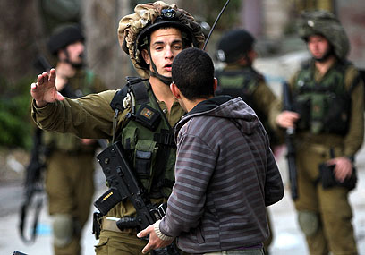 חיילים מול פלסטינים בחברון (צילום: EPA)