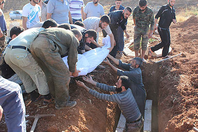 קוברים הרוגים בסוריה (צילום: רויטרס)