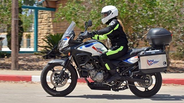 ראו הוזהרתם השוטרת הצבאית רוכבת על סוזוקי