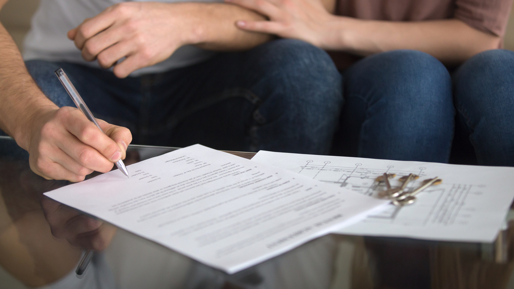 זוג חותם על חוזה (צילום: Shutterstock)