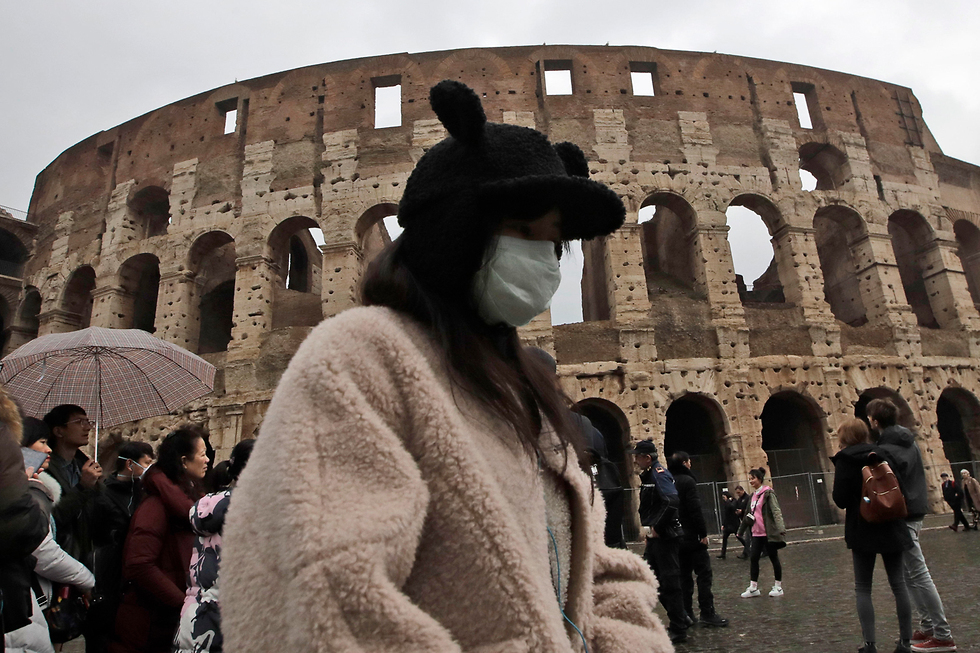 לא יעד מוצלח לטוס אליו בימים אלו: תיירים במסיכות בקולוסיאום ברומא (צילום: AP)