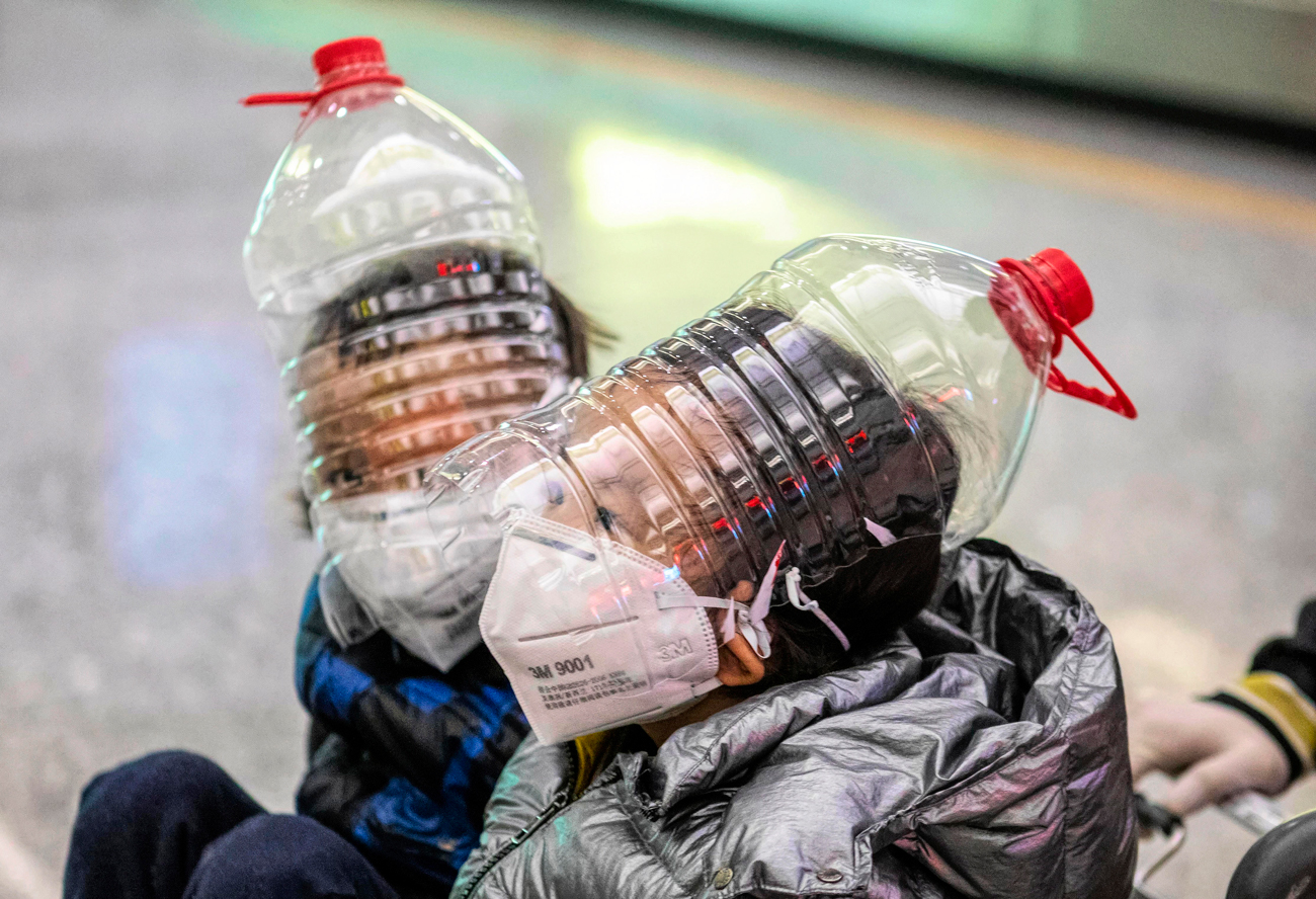 Chinese children at Beijing airport use empty water bottles are makeshift masks to counter the coronavirus  (Photo: EPA)