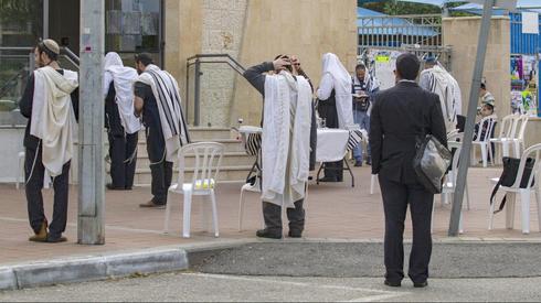 Jews praying outside of a closed synagogue in Netanya  ()